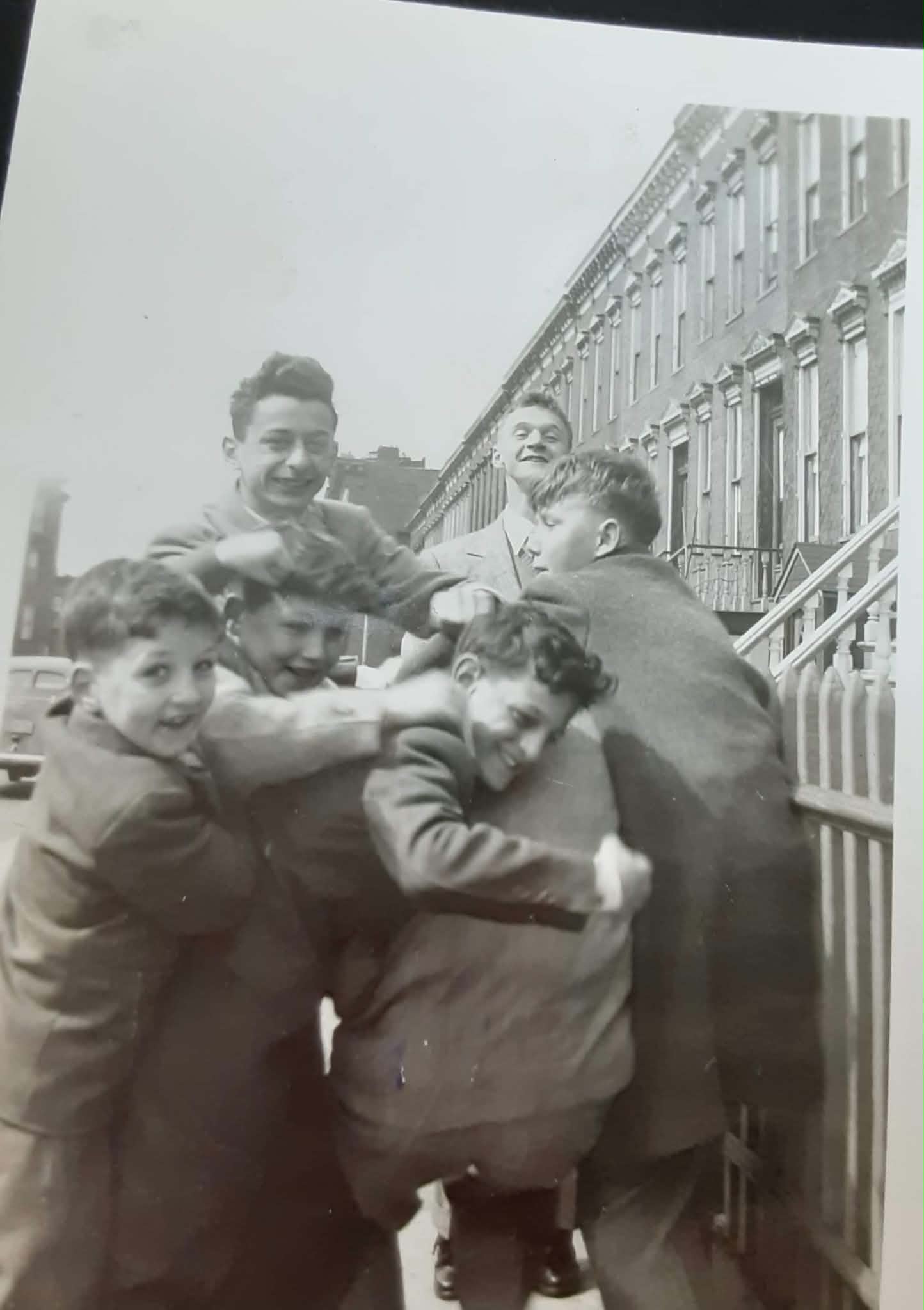 Boys of Windsor roughhousing on the street, 1948 — Windsor Place row houses fill the background.